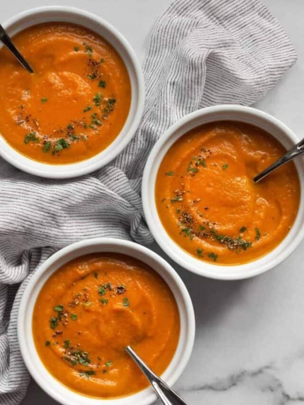 Three bowls of roasted carrot soup.