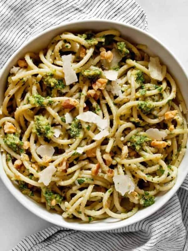 Spaghetti in a bowl tossed with parsley pesto.