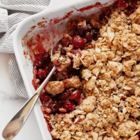 Portion spooned out of cherry crumble in baking dish.