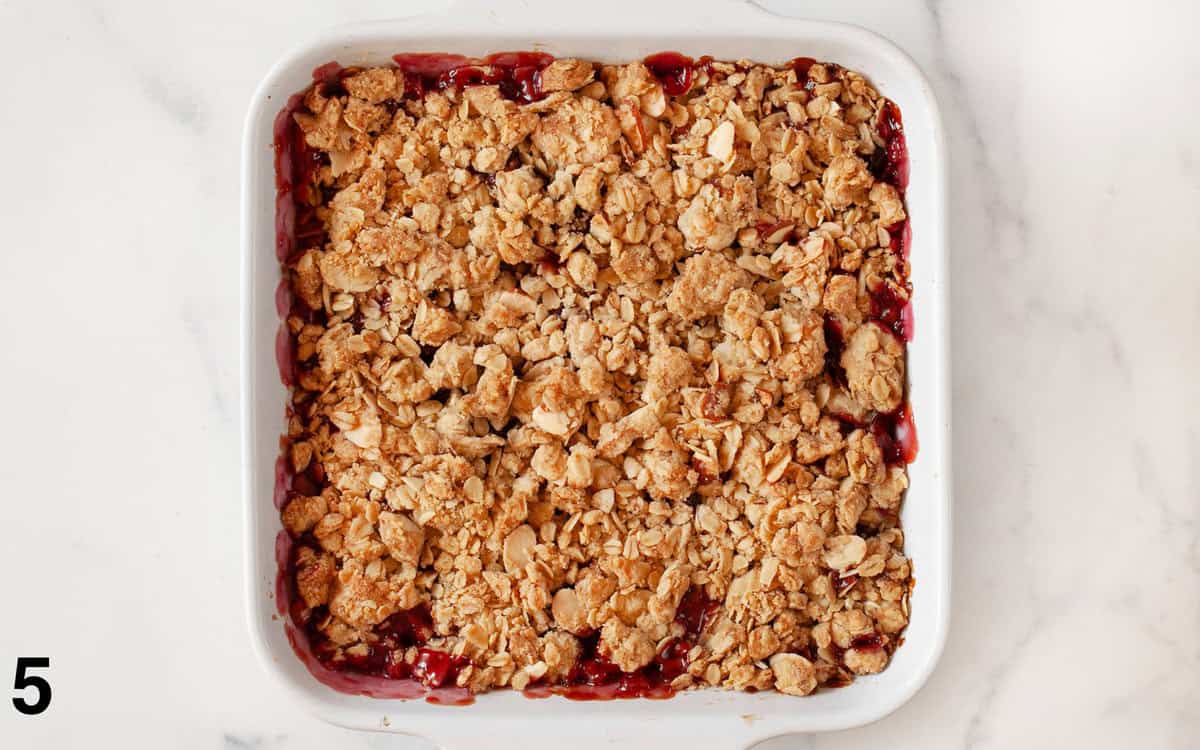 Cherry crumble in a square baking dish.