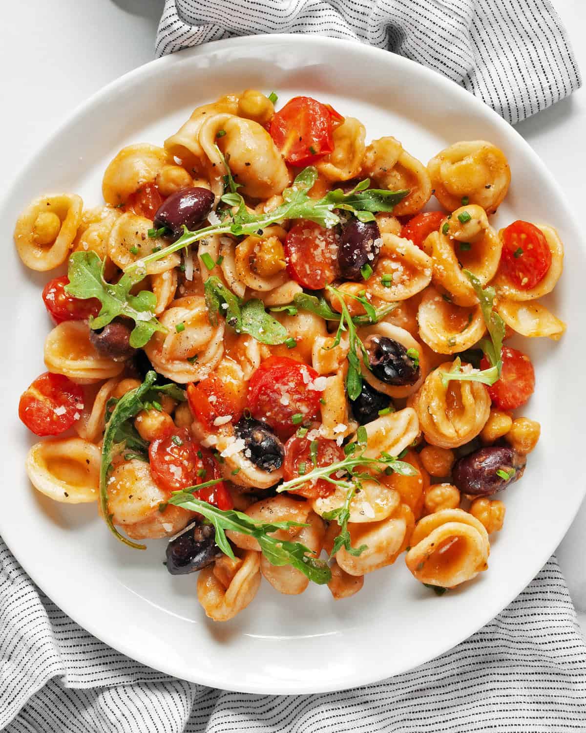 One pan pasta with chickpeas, tomatoes and olives on a plate.