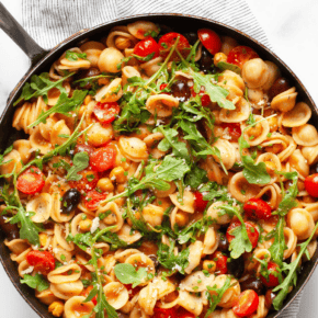 One pan pasta with chickpeas, tomatoes and olives in a skillet.