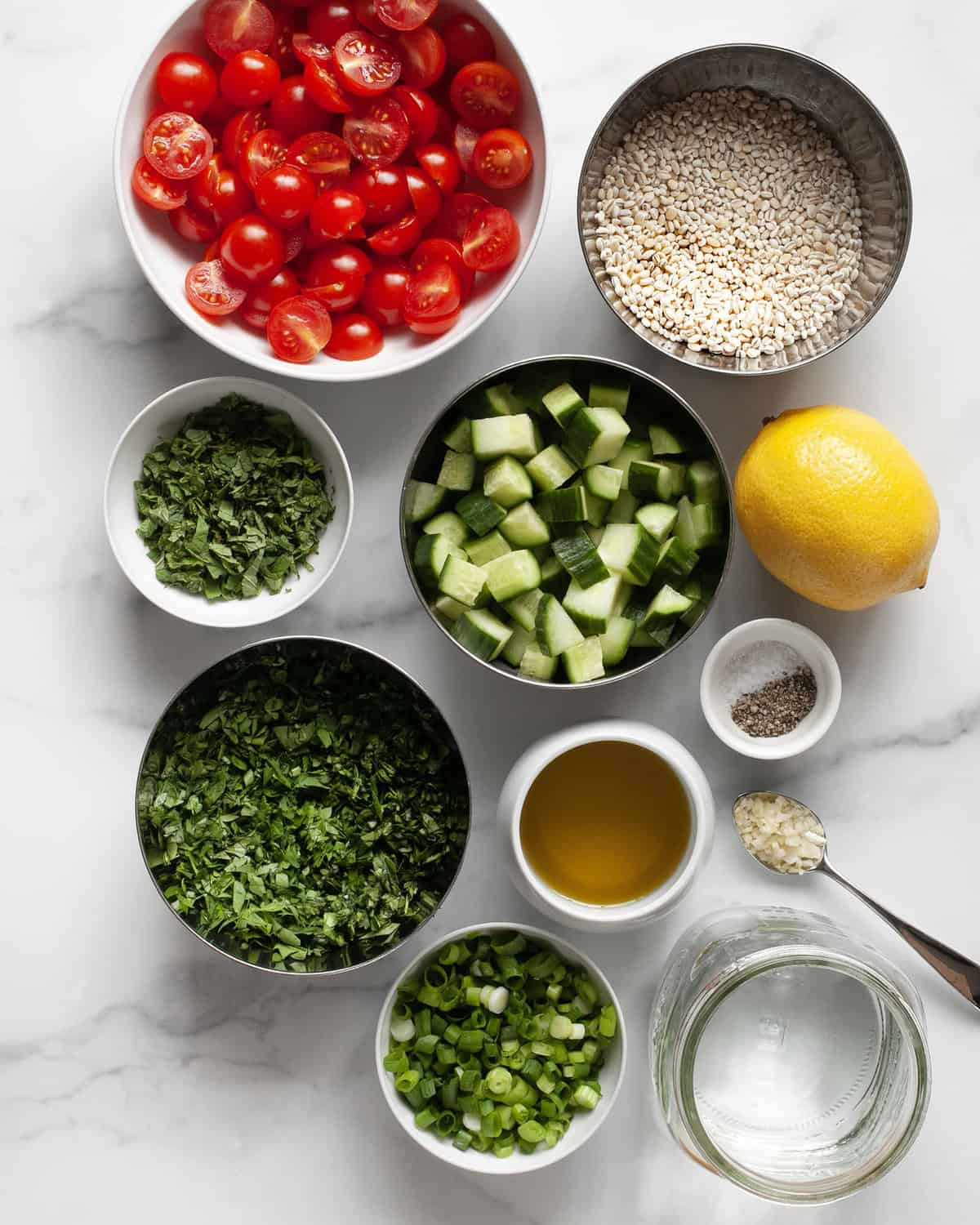 Ingredients including parsley, mint, lemon, olive oil, tomatoes, cucumbers, scallions, garlic and barley.