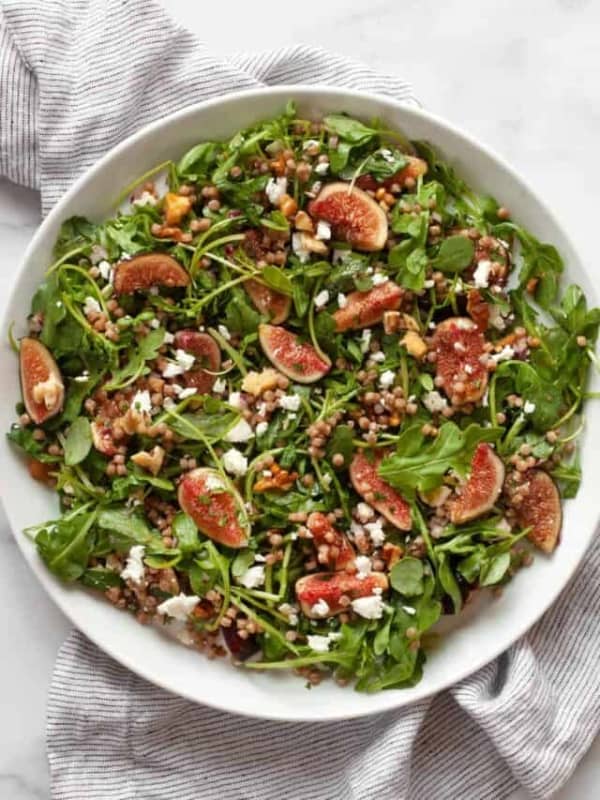 Fresh fig salad with arugula and couscous on a plate.