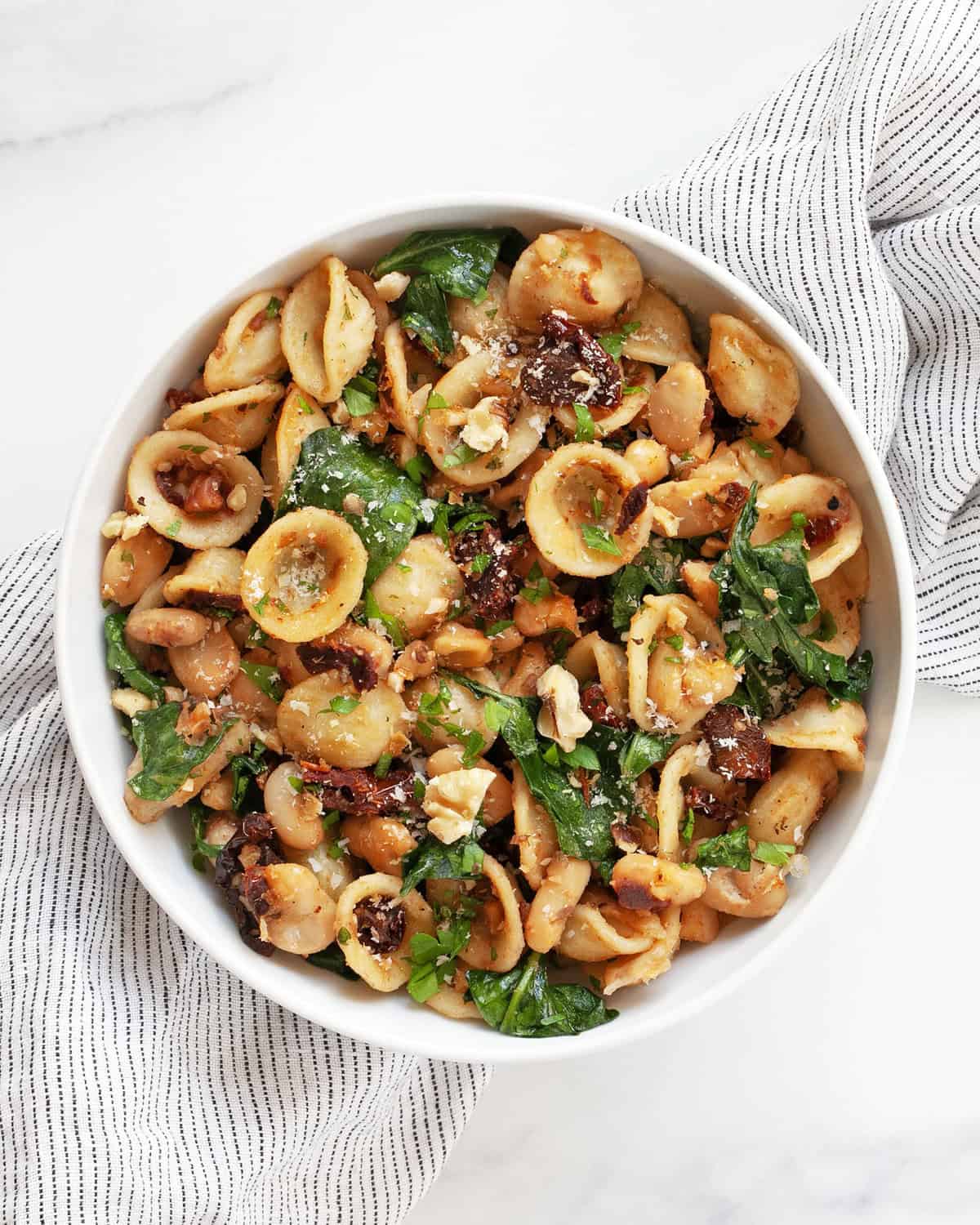 White bean sun-dried tomato pasta in a small bowl.