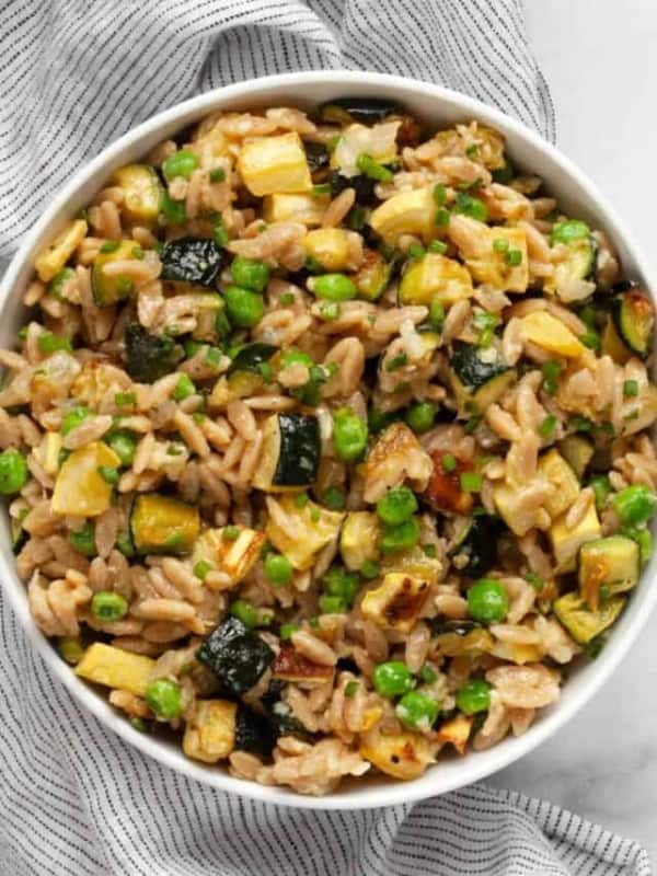 Parmesan orzo with squash and zucchini in bowl.