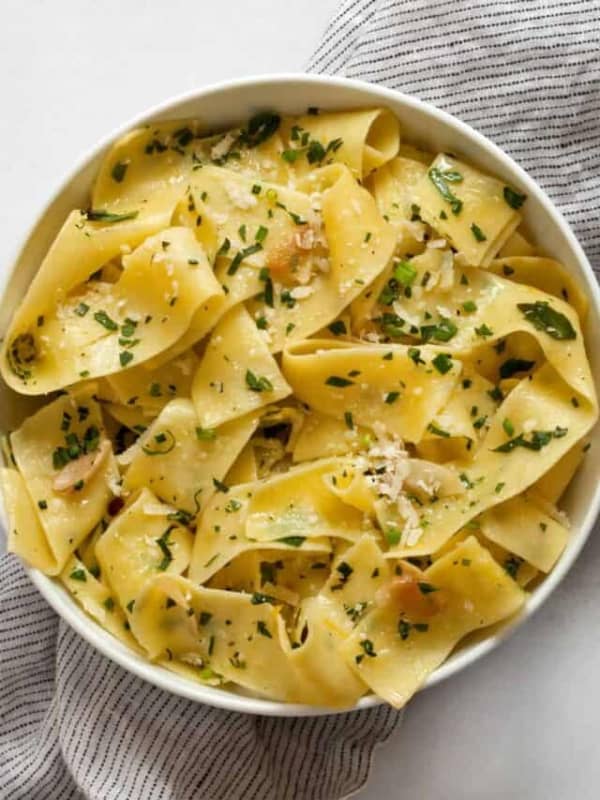 Herb pappardelle pasta in a small bowl.