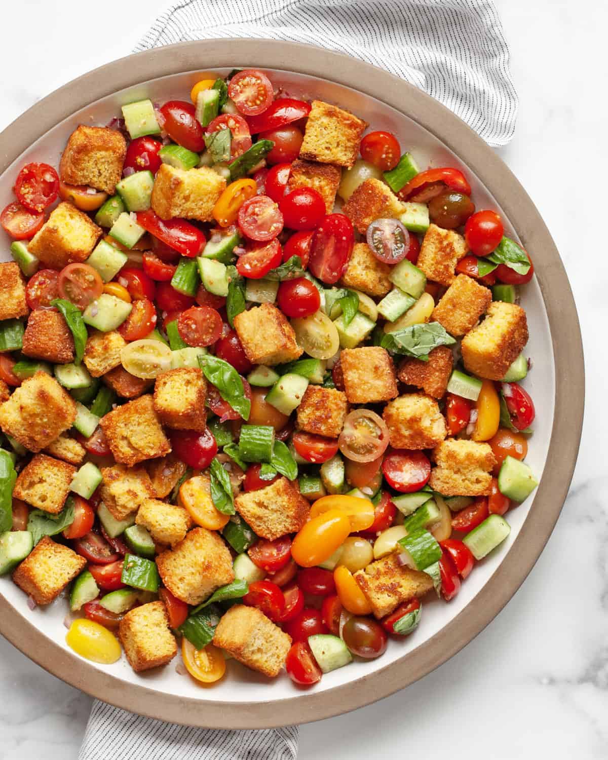 Panzanella salad with toasted cornbread on a large platter.