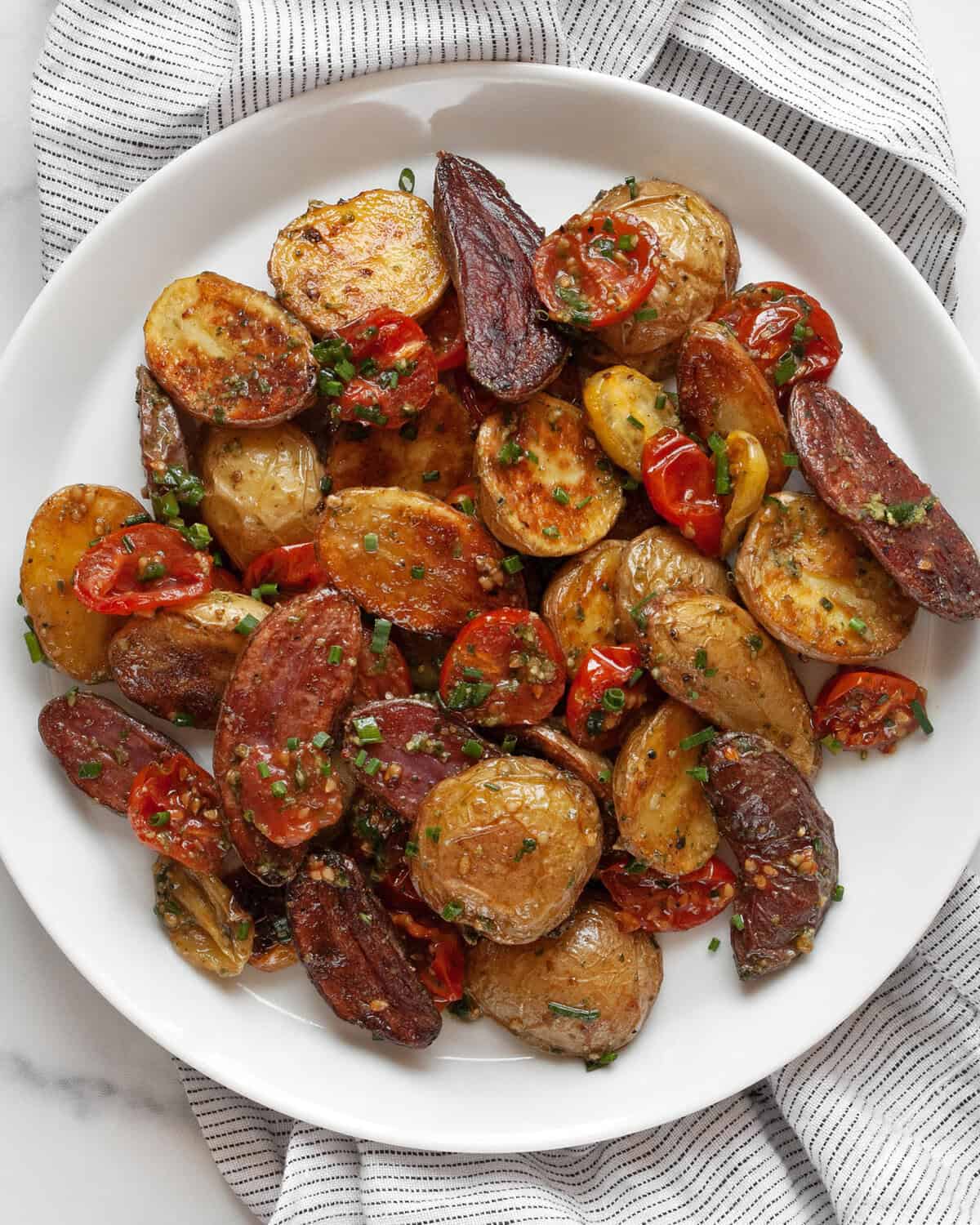 Roasted potato salad with potato and pesto viniagrette on a plate.