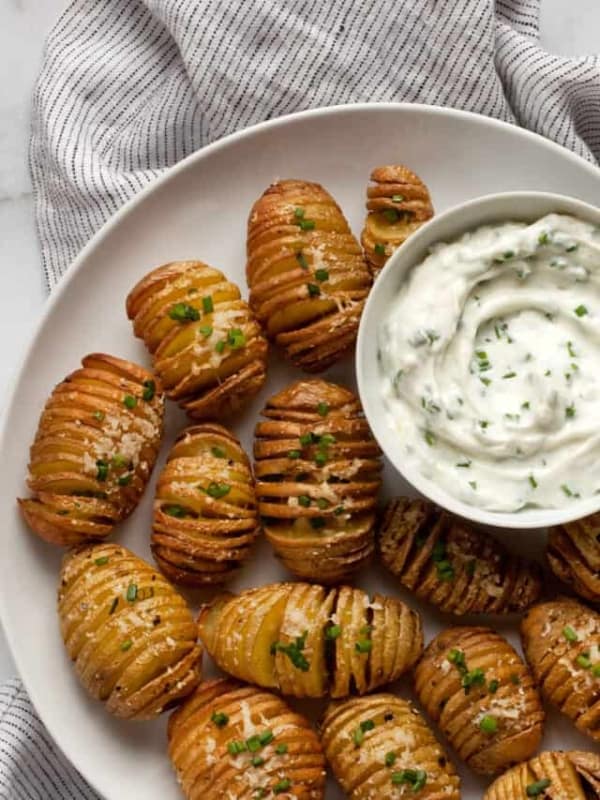 Herby yogurt dip served with mini hasselback potatoes.