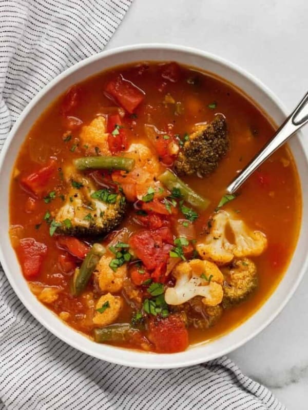 Vegetable soup with broccoli, greens beans and cauliflower in a bowl.