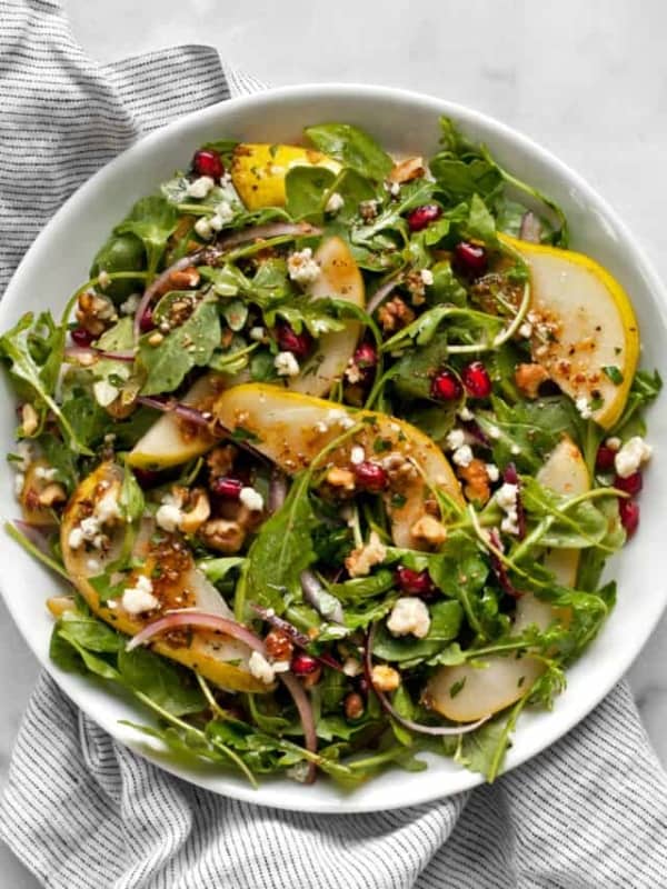 Arugula salad with pears and gorgonzola on a plate.