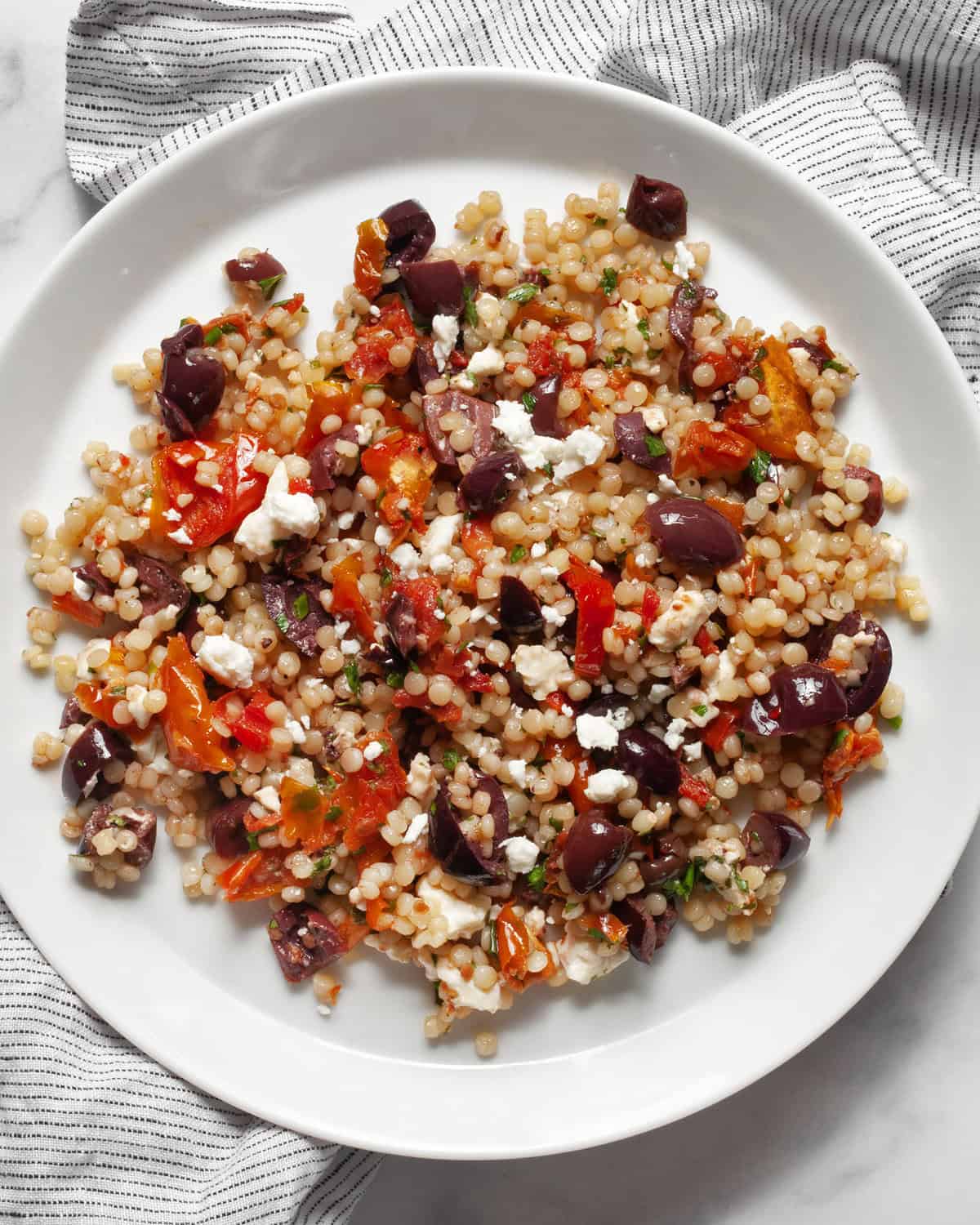 Tomato olive couscous on a plate.