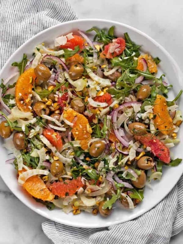 Fennel salad with oranges, olives and arugula on a plate.