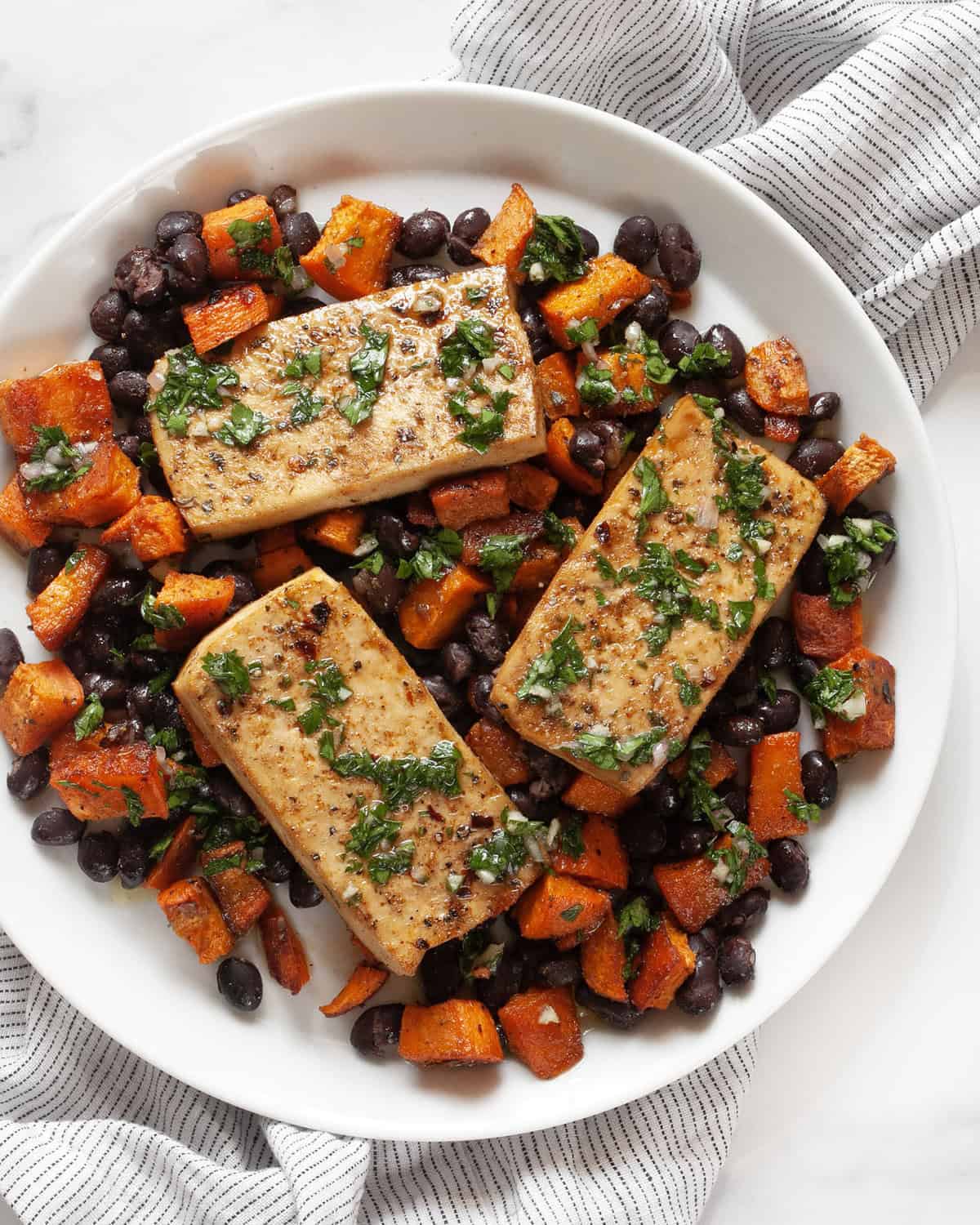 Sheet pan tofu, sweet potato and black beans on a plate.