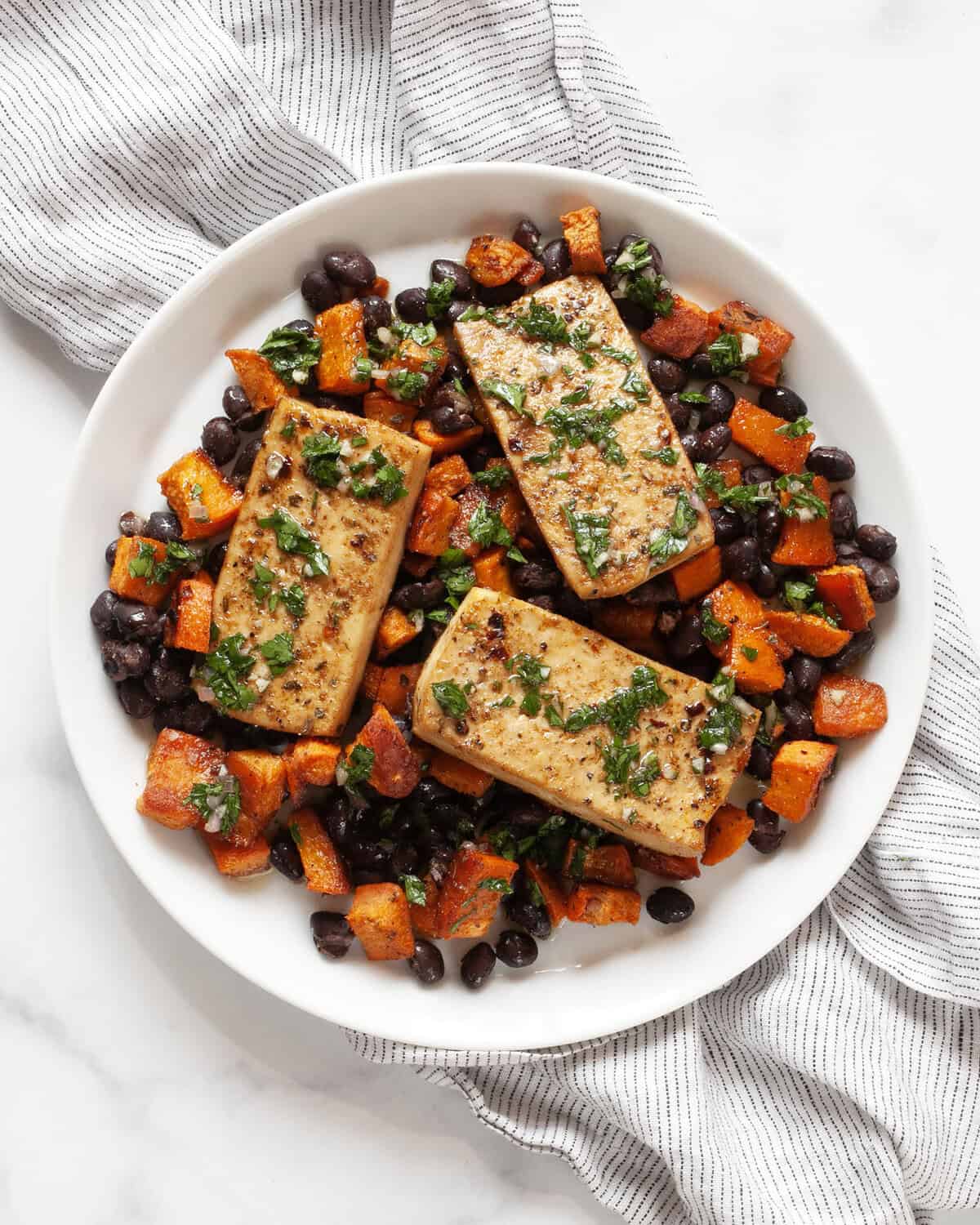 Sheet pan tofu, sweet potato and black beans on a plate.