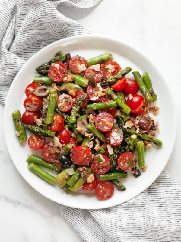 Grilled asparagus tomato salad on a plate.