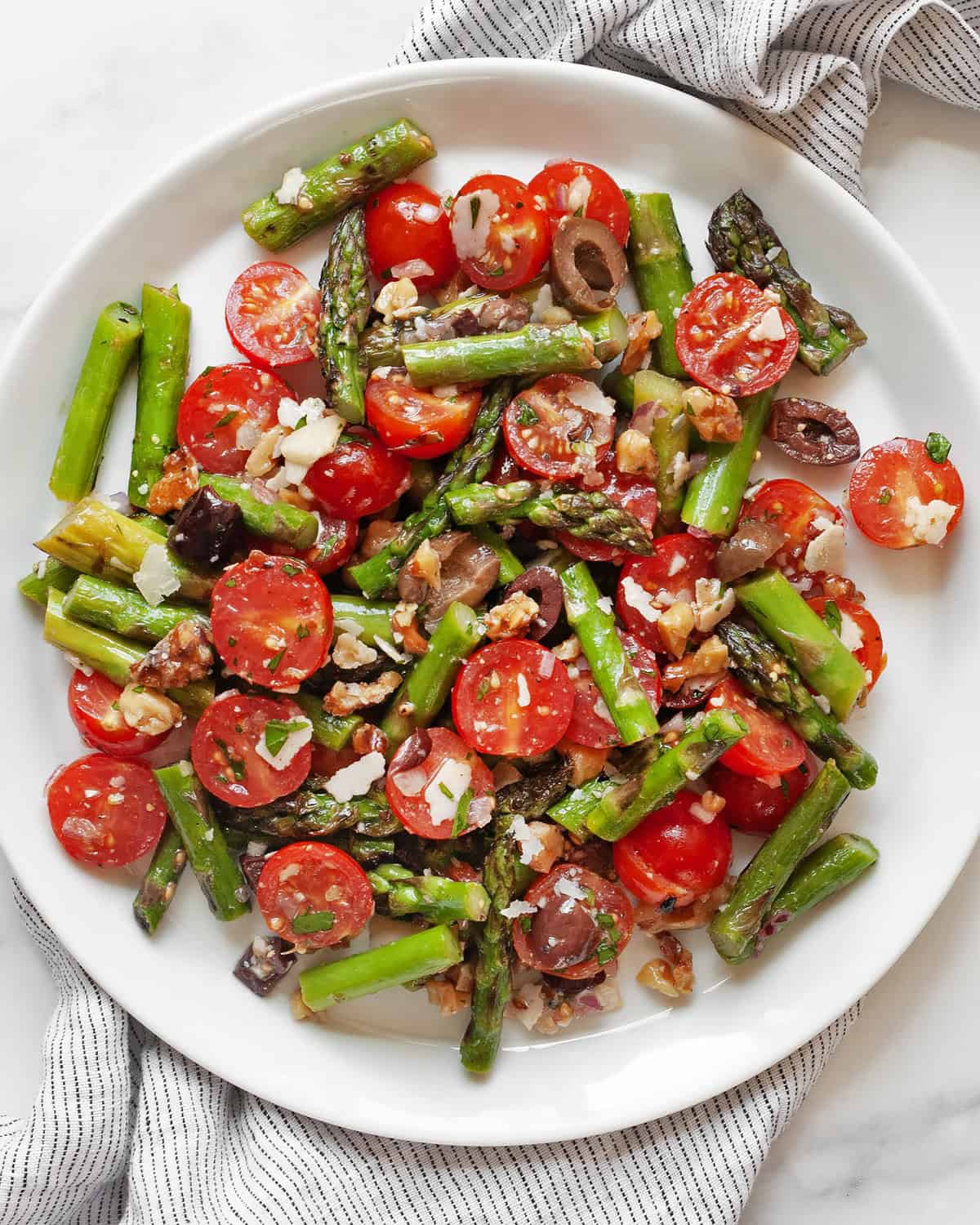 Grilled asparagus tomato salad on a plate.