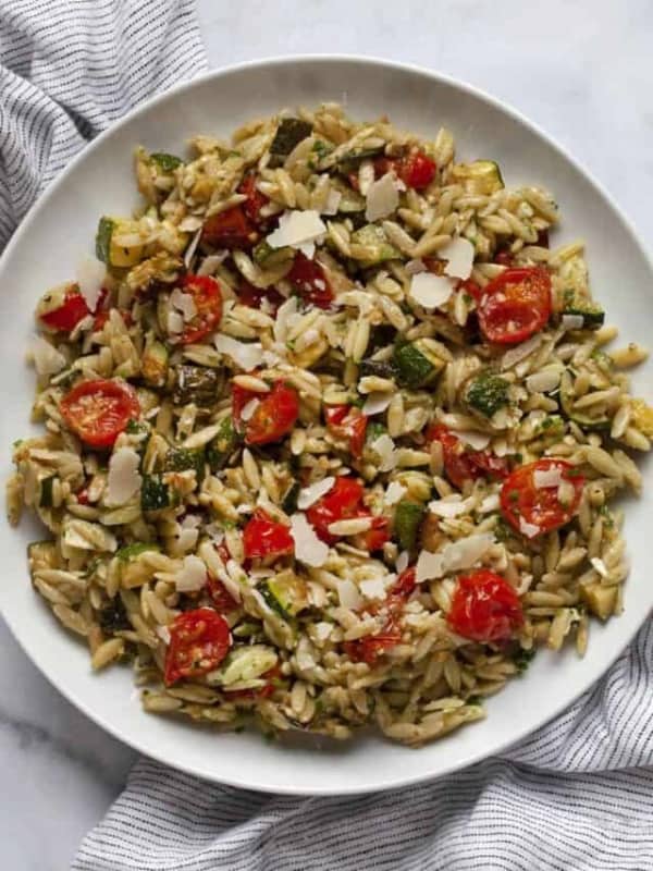 Roasted tomato zucchini orzo on a plate.