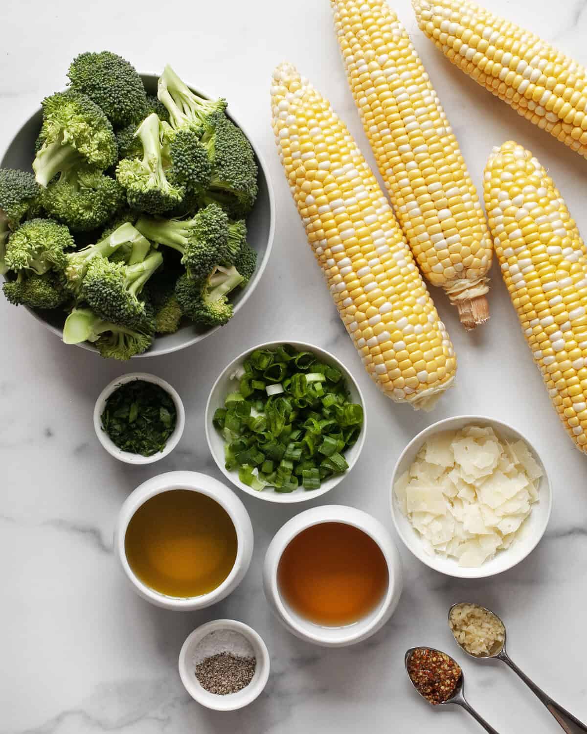Ingredients including corn, broccoli, scallions, pecorino, parsley, garlic, mustard, white balsamic vinegar and olive oil.