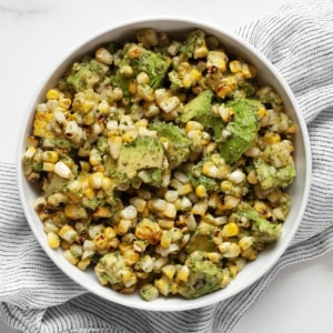 Grilled corn and avocados with cilantro pesto in a bowl.