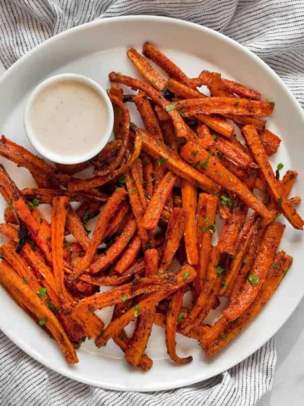 Healthy baked fries on a plate with tahini dipping sauce.