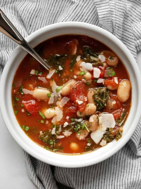 Tomato soup with white beans and kale in a bowl.