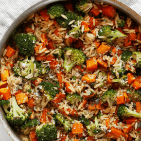 Roasted vegetable orzo with butternut quash and broccoli in a skillet.