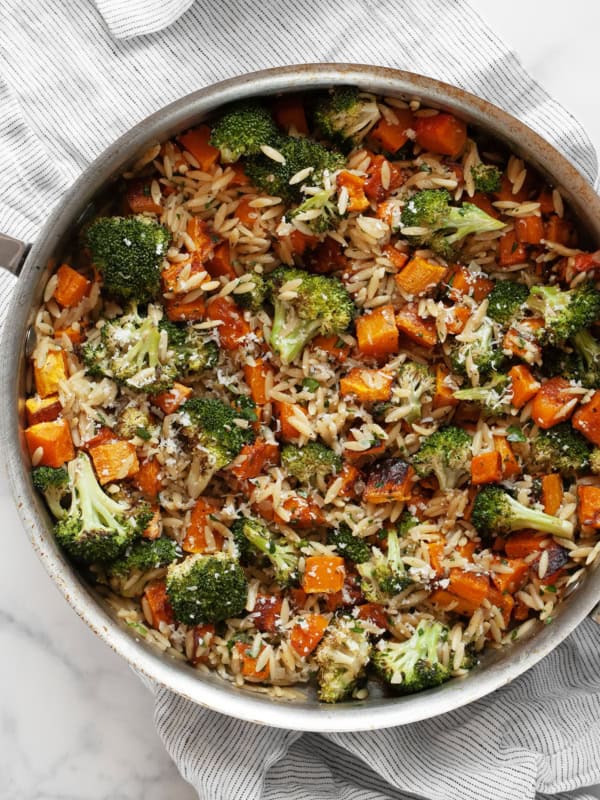 Roasted vegetable orzo with butternut quash and broccoli in a skillet.