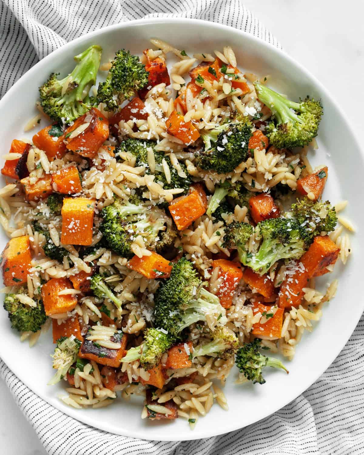 Roasted butternut squash broccoli orzo on a plate.