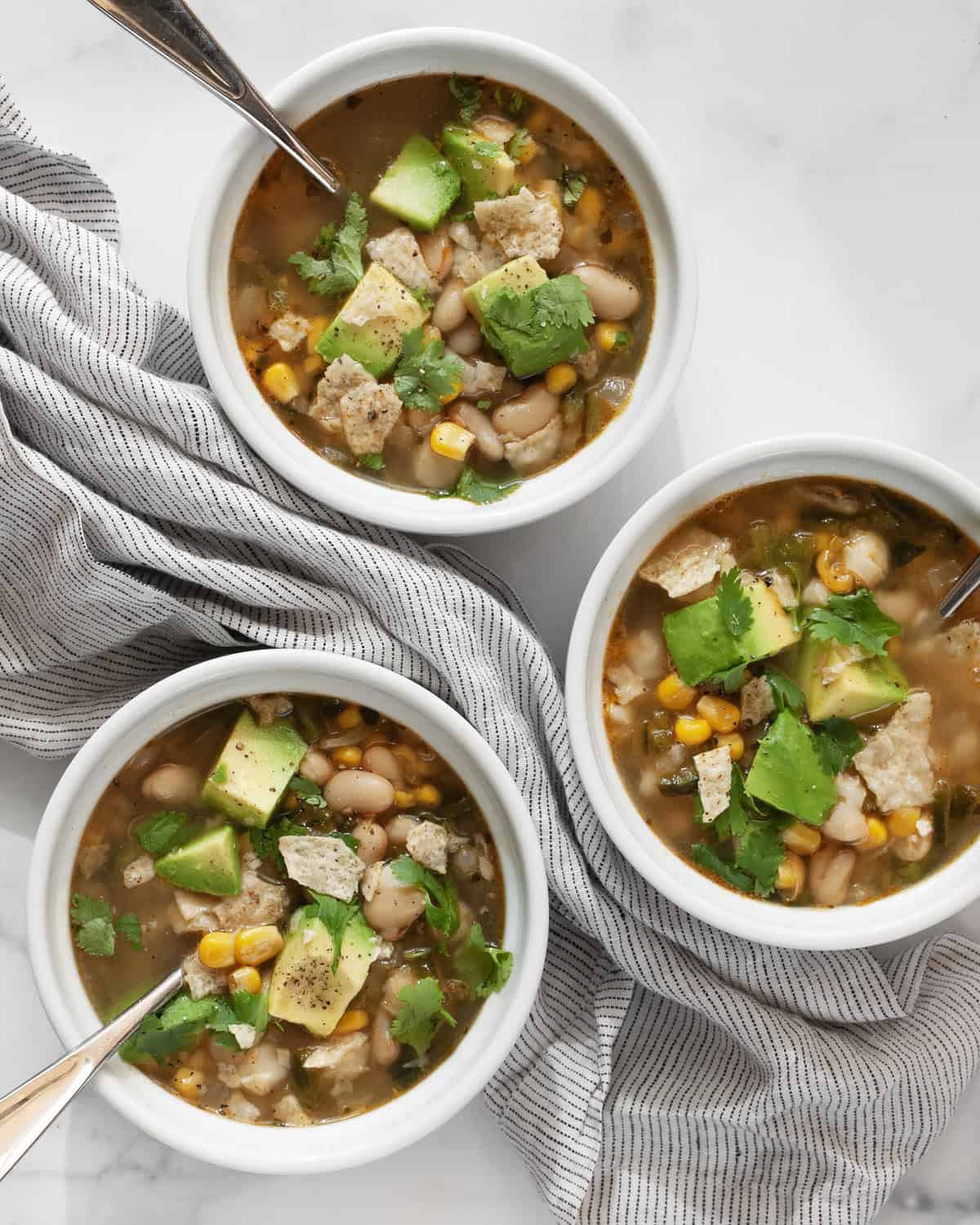 Three bowls of white bean chili.