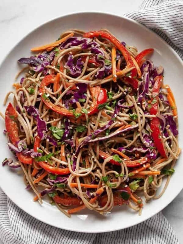 Soba noodle, cabbage, carrot and pepper salad on a plate.