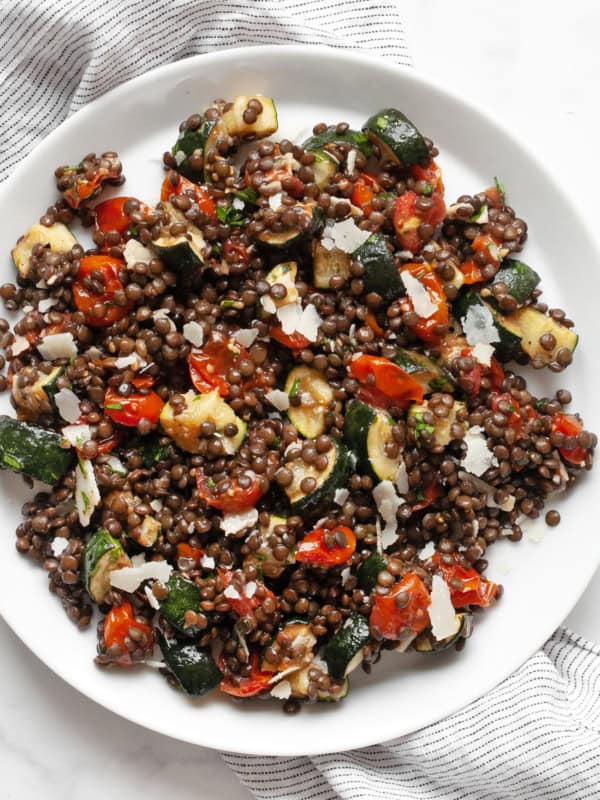 Roasted tomato zucchini lentil salad on a plate.