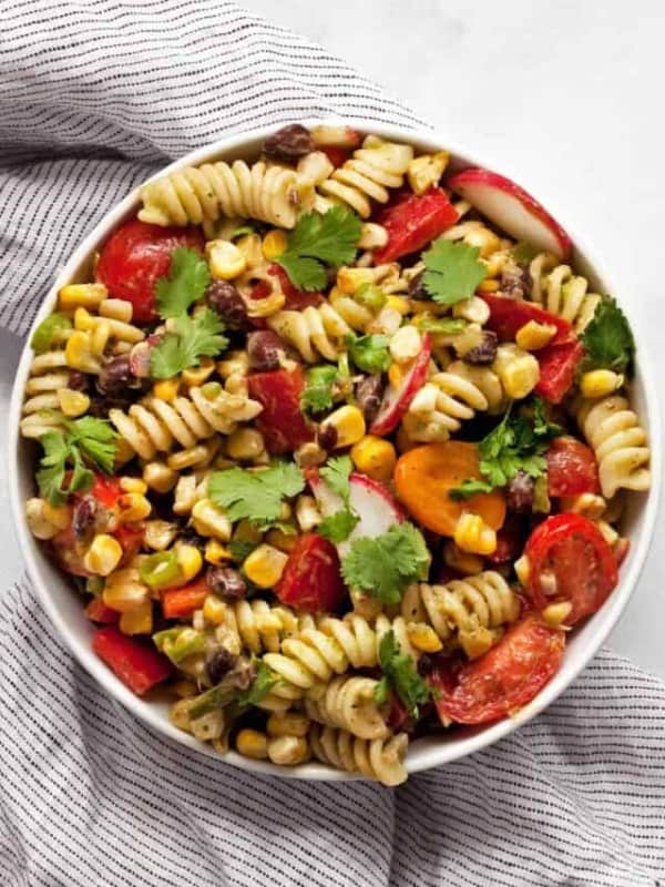 Grilled corn black bean pasta salad with avocado lime dressing in a bowl.