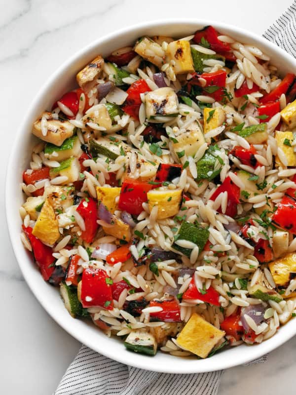 Grilled vegetable orzo pasta salad in a bowl.