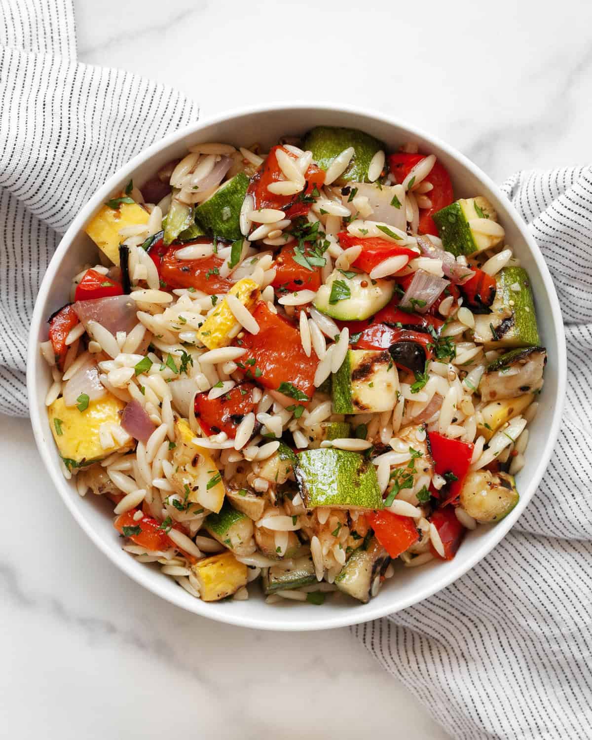 Grilled vegetable orzo salad in a small bowl.