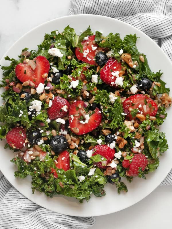 Kale salad with berries on a plate.