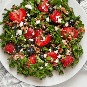 Mixed berry kale salad on a plate.