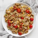 Tomato corn pasta on a plate.