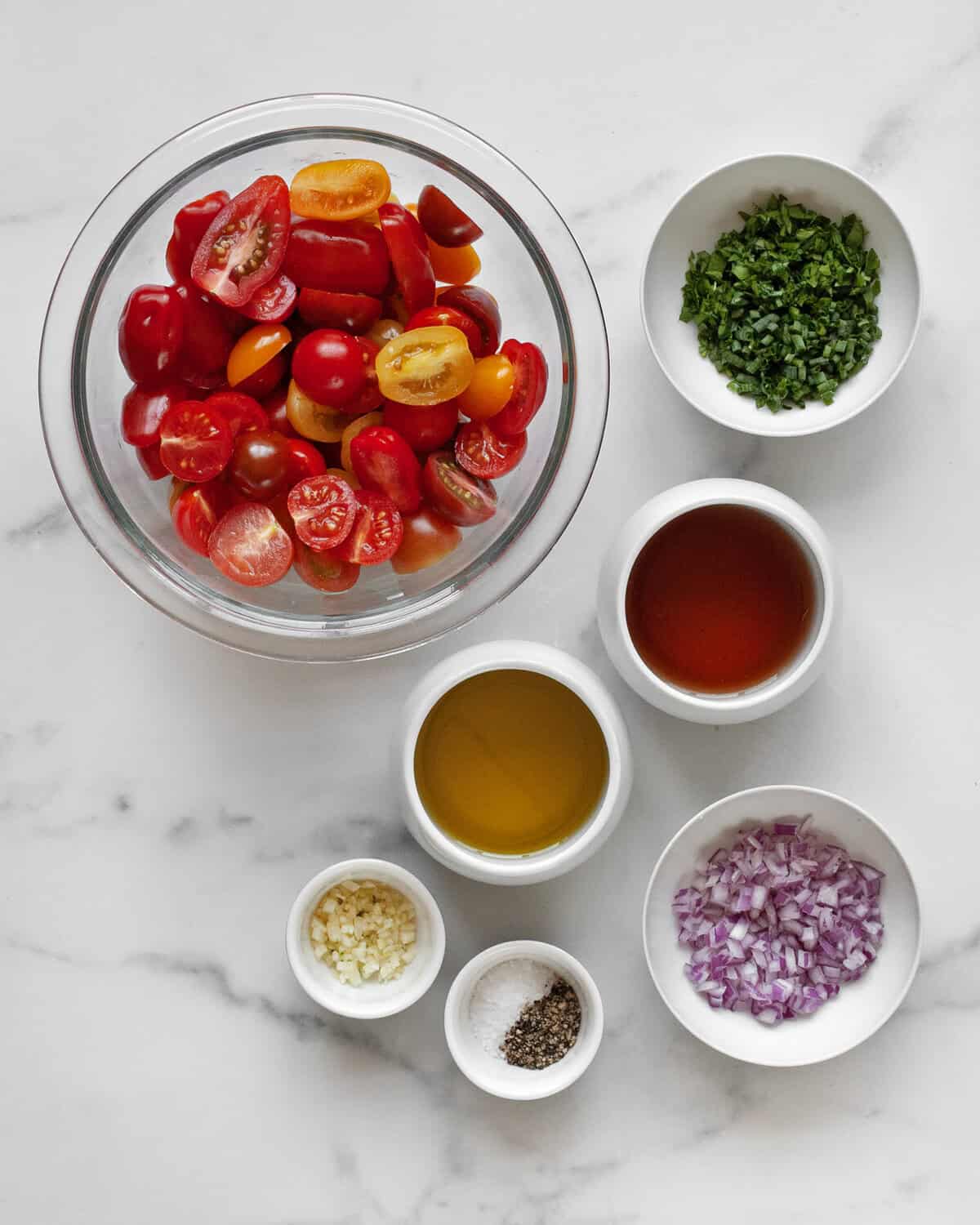 Ingredients including tomatoes, herbs, garlic, vinegar, oil, onions, salt and pepper.