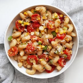 Pasta with corn pesto and roasted tomatoes in a bowl.
