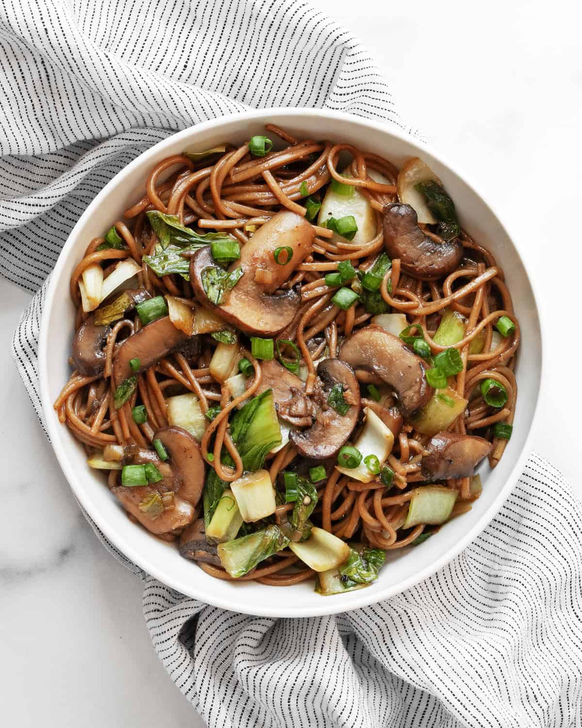 Mushroom and bok choy soba noodle stir-fry in a a bowl.