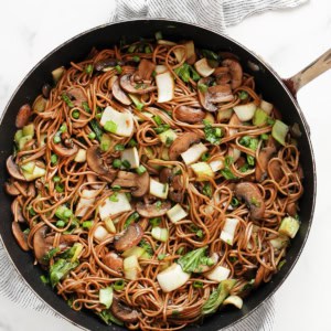 Mushroom and bok choy soba noodle stir-fry in a skillet.