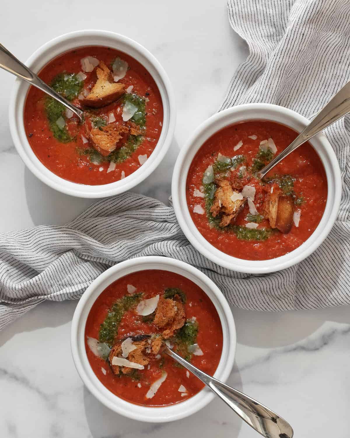 Three bowls of roasted tomato soup.