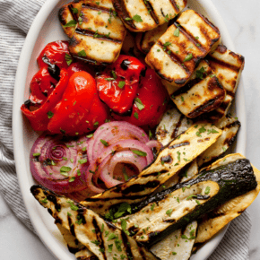 Grilled halloumi and veggies on an oval platter.
