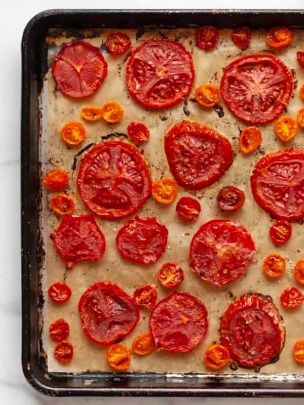 Sliced roasted tomatoes on a sheet pan.