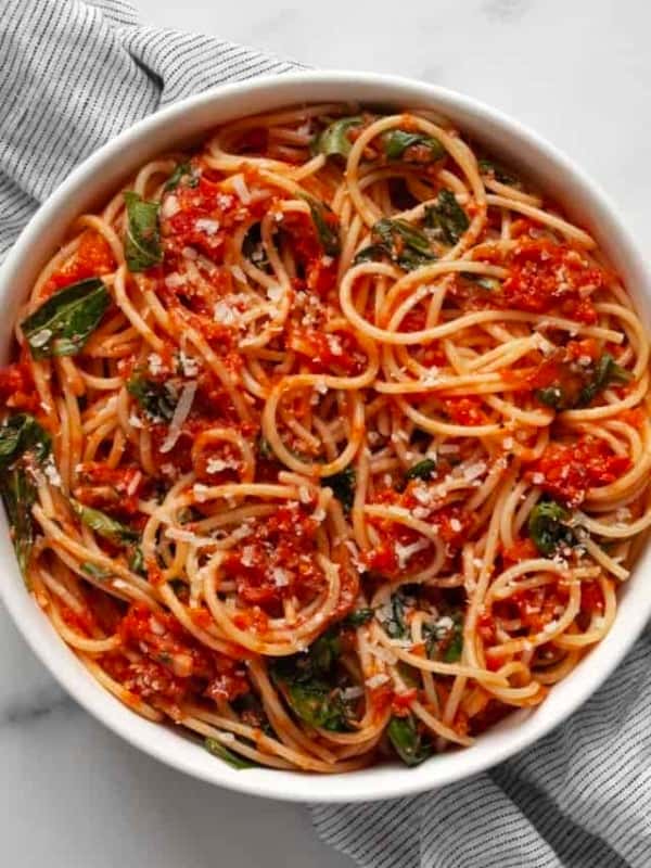 Fresh tomato pasta with basil in a bowl.