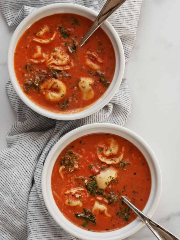 Two bowls of tomato tortellini soup.