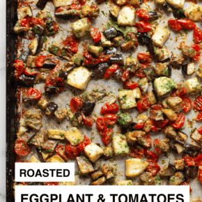 Sauce tossed with eggplant, tomatoes and halloumi on a sheet pan.