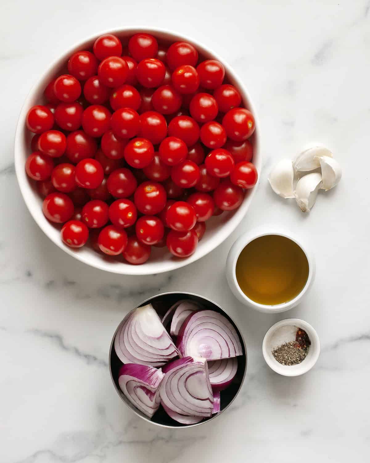 Ingredients including cherry tomatoes, onions, garlic, olive oil and seasonings.